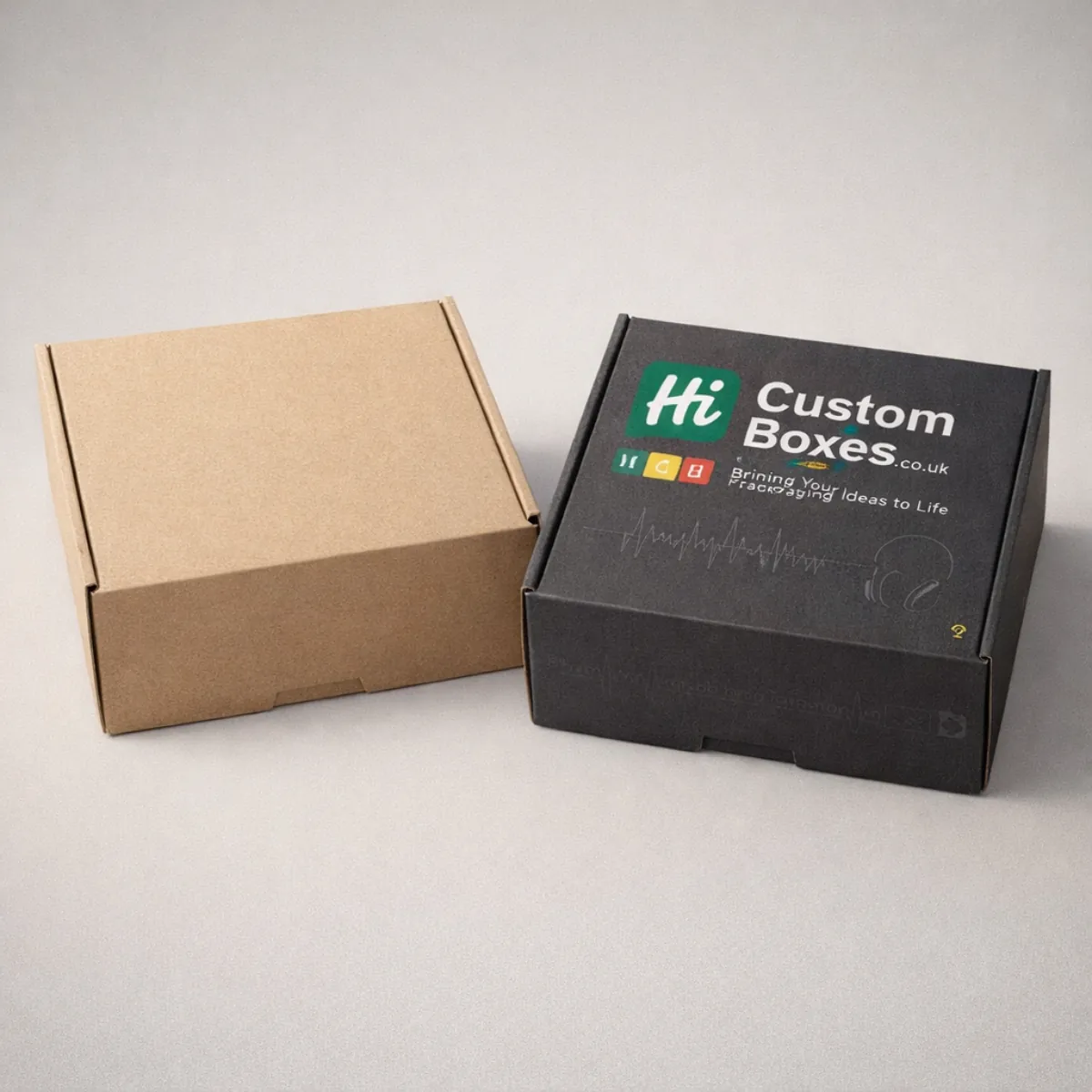 A plain brown biodegradable mailer box next to a black eco-friendly box with printed white graphics. class=